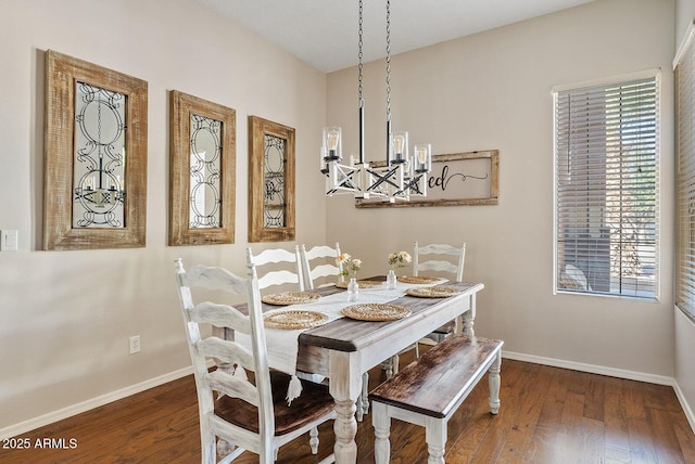 dining area featuring dark wood-type flooring and an inviting chandelier