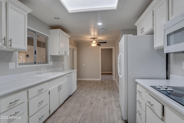 kitchen with light countertops, white cabinetry, a sink, ceiling fan, and white appliances