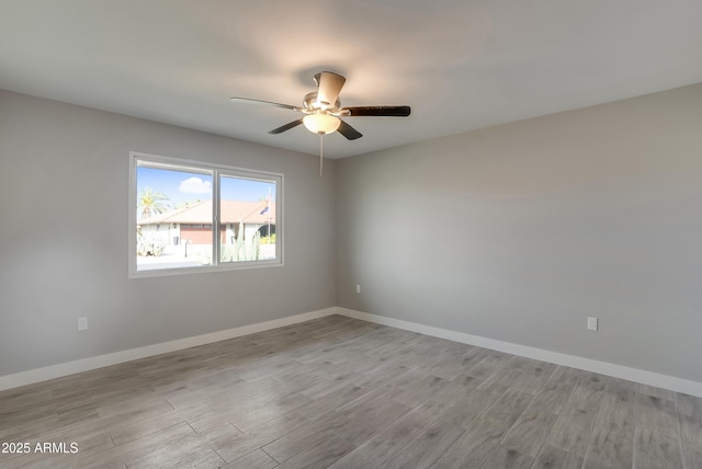 empty room featuring ceiling fan, wood finished floors, and baseboards