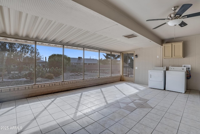 unfurnished sunroom with washing machine and dryer, visible vents, and a ceiling fan