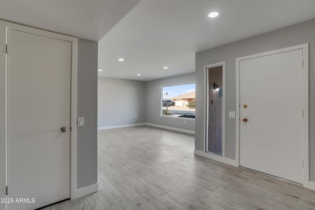 foyer with baseboards, light wood-style flooring, and recessed lighting