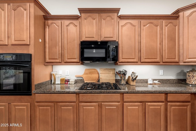 kitchen featuring dark stone countertops and black appliances