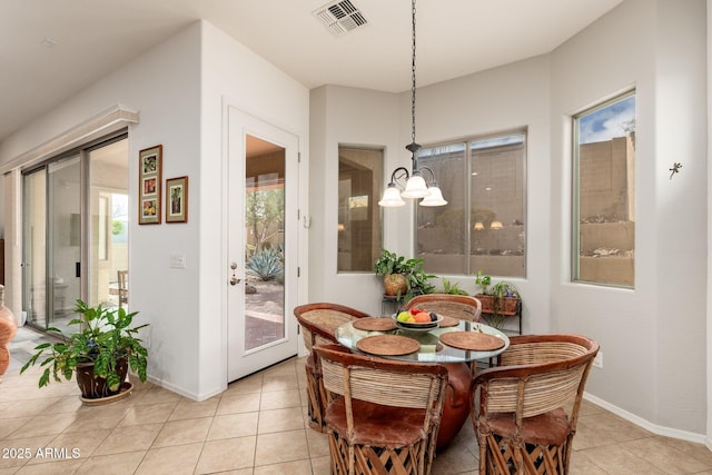 tiled dining area featuring a notable chandelier