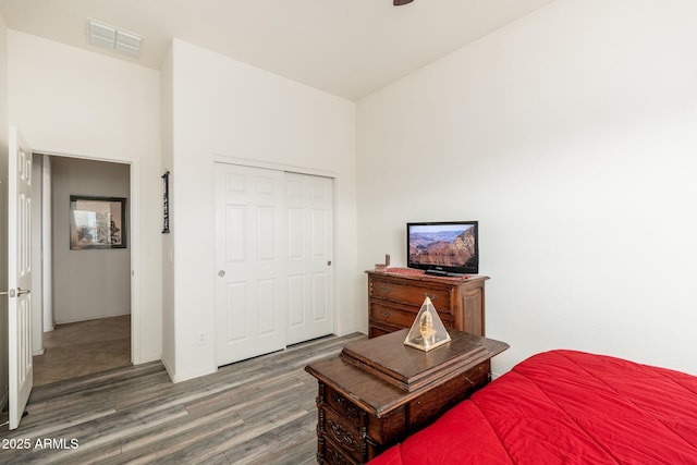 bedroom with dark hardwood / wood-style flooring and a closet