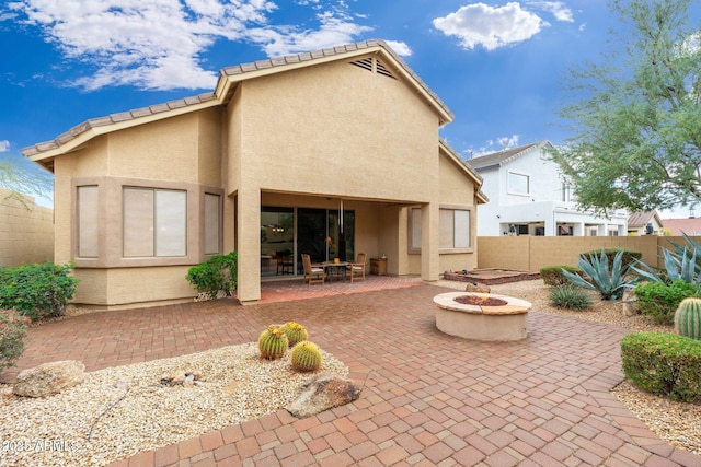 back of property featuring a patio area and an outdoor fire pit