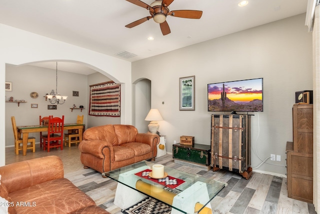 living room featuring wood-type flooring and ceiling fan with notable chandelier