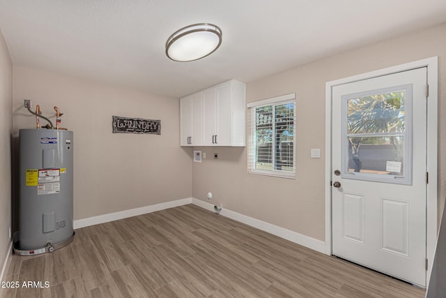 laundry area featuring cabinet space, electric dryer hookup, baseboards, and electric water heater