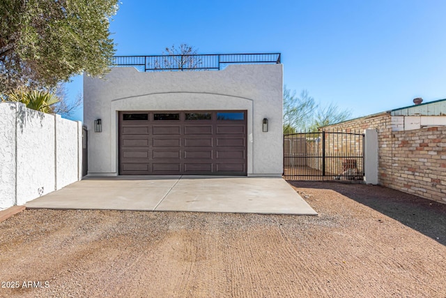 garage featuring fence and dirt driveway