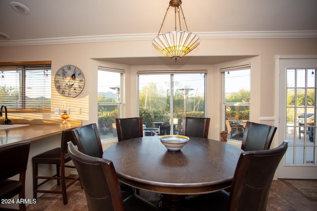 dining space with a notable chandelier, a healthy amount of sunlight, and crown molding