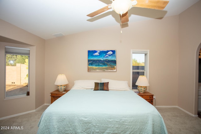 carpeted bedroom featuring multiple windows, vaulted ceiling, and ceiling fan