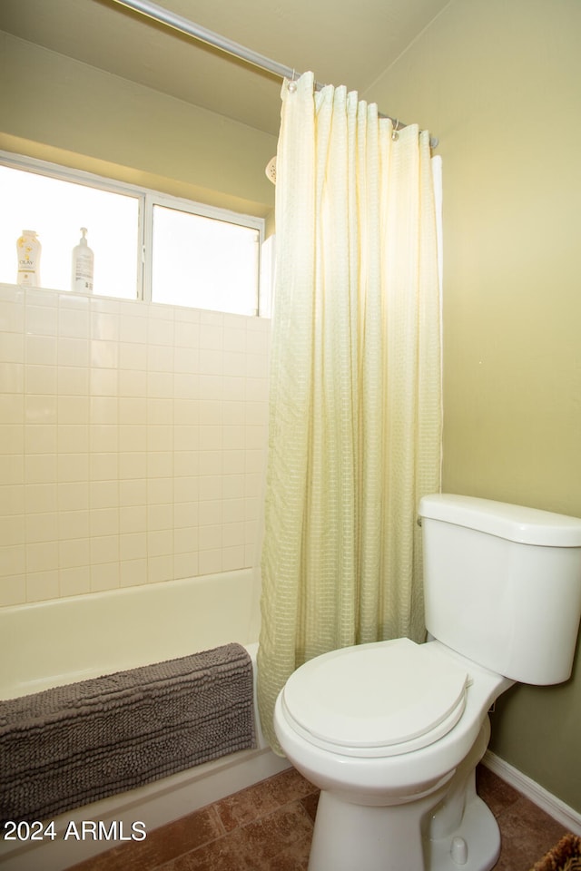 bathroom featuring tile patterned floors, toilet, and shower / tub combo with curtain