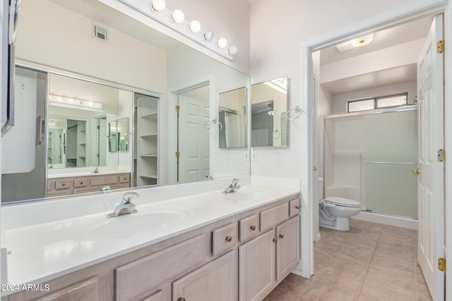 bathroom with tile flooring, dual sinks, vanity with extensive cabinet space, and toilet