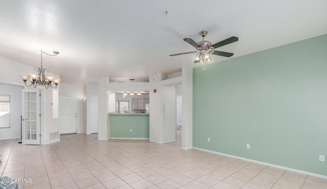 tiled empty room with ceiling fan with notable chandelier