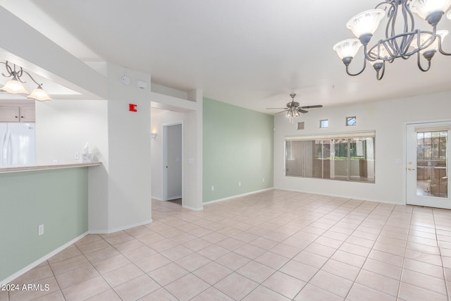 spare room featuring light tile floors and ceiling fan with notable chandelier