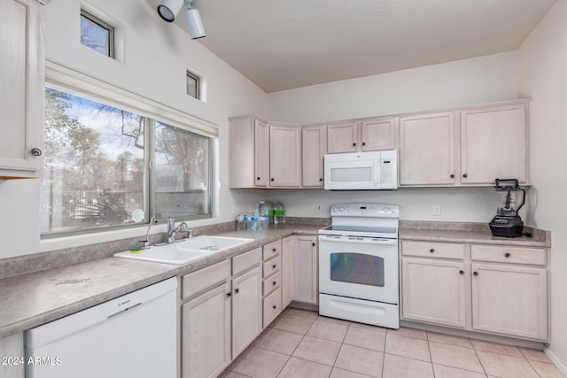 kitchen with white appliances, sink, and light tile floors