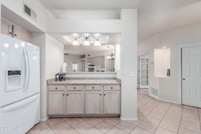 kitchen with light tile floors, a notable chandelier, hanging light fixtures, and white fridge with ice dispenser