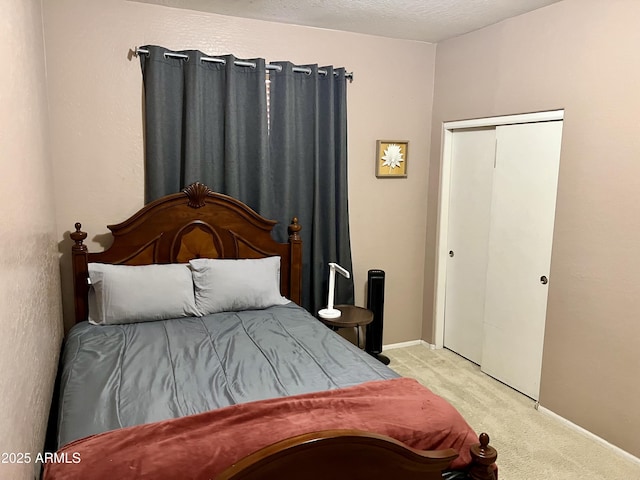 carpeted bedroom with a closet and a textured ceiling