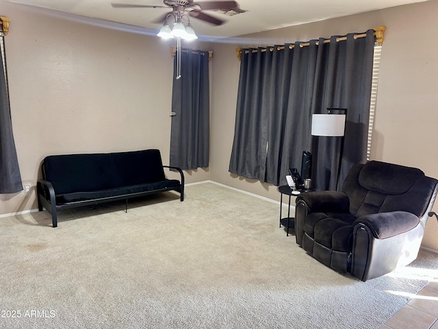 living area featuring light carpet and ceiling fan