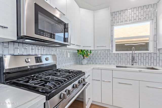 5210 W Jupiter Way N, Chandler, AZ 85226 - kitchen featuring stainless steel appliances, decorative backsplash, white cabinetry, and light stone counters