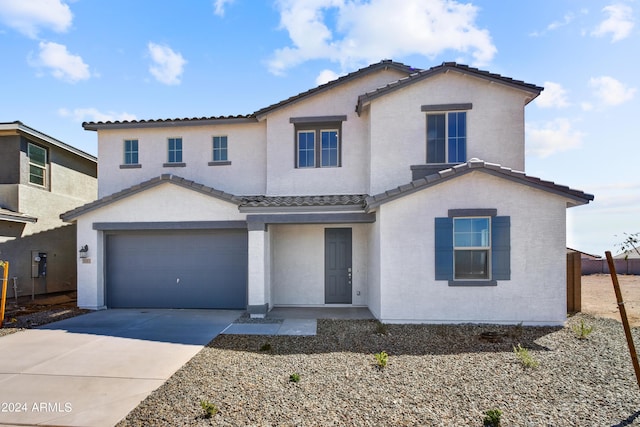 view of front facade featuring a tile roof, concrete driveway, a garage, and stucco siding