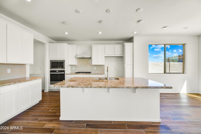 kitchen featuring a sink, black appliances, dark wood-style floors, white cabinets, and recessed lighting