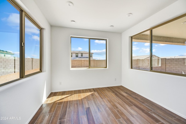 spare room with wood finished floors and baseboards