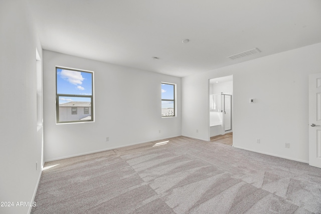 spare room with light colored carpet and baseboards