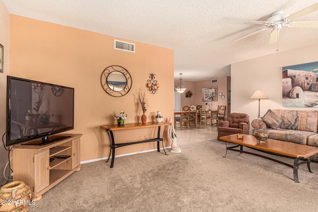 living room featuring a textured ceiling, light colored carpet, and ceiling fan