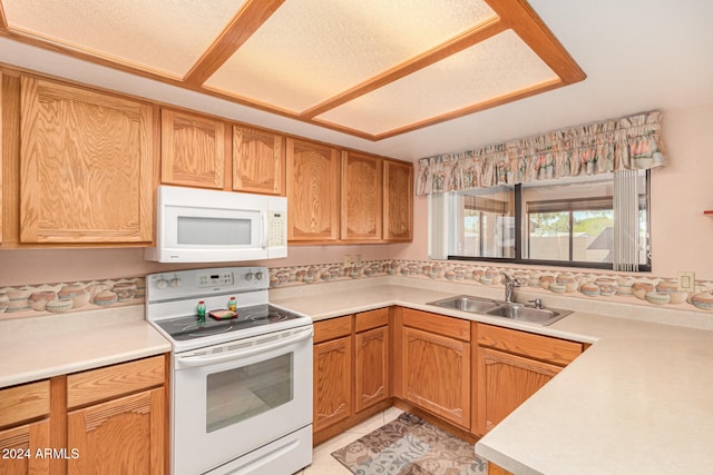 kitchen with a textured ceiling, sink, light tile patterned floors, and white appliances