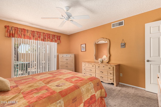 carpeted bedroom featuring ceiling fan, access to exterior, and a textured ceiling