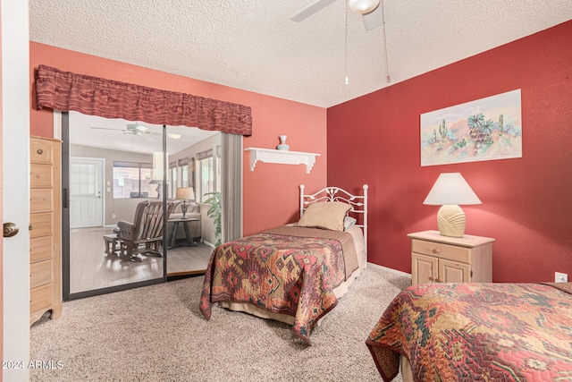 bedroom featuring ceiling fan, light colored carpet, and a textured ceiling