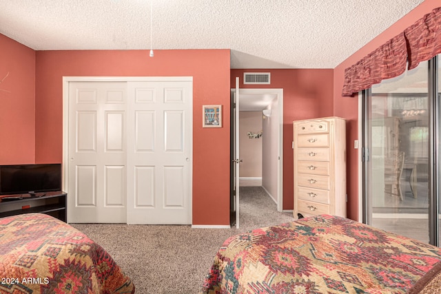 bedroom featuring a closet, light colored carpet, and a textured ceiling