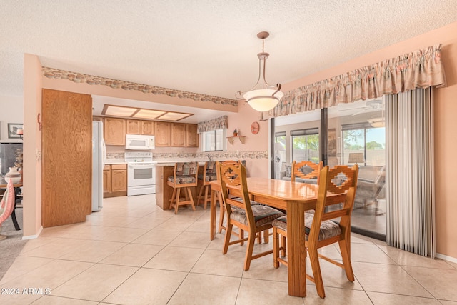 tiled dining space with a textured ceiling