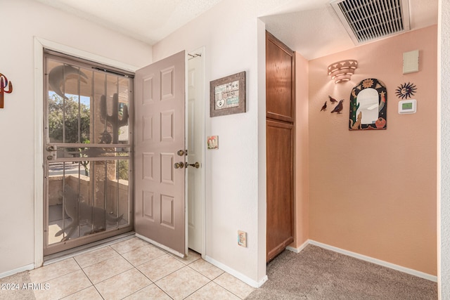 tiled entryway featuring a textured ceiling