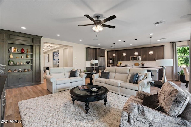 living room with light wood-type flooring and ceiling fan