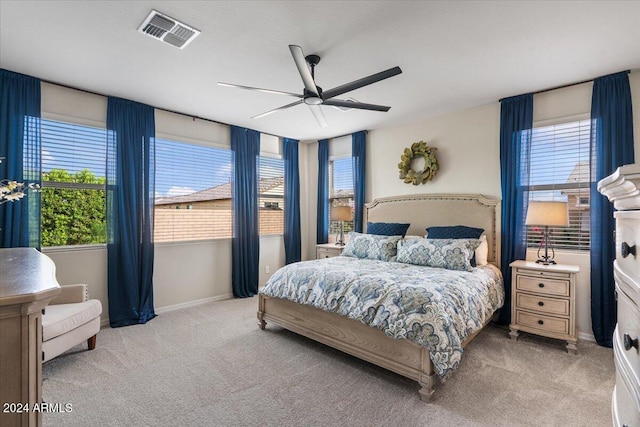 carpeted bedroom featuring multiple windows and ceiling fan