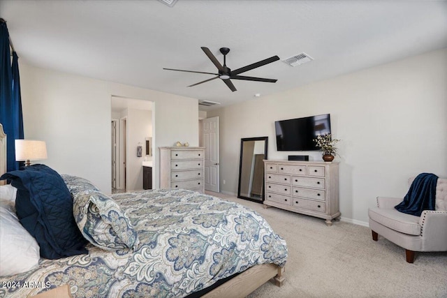 bedroom with ensuite bathroom, ceiling fan, and light colored carpet