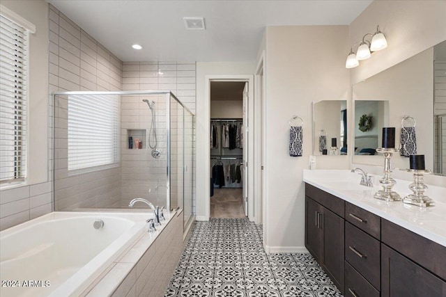 bathroom featuring tile patterned flooring, shower with separate bathtub, and vanity