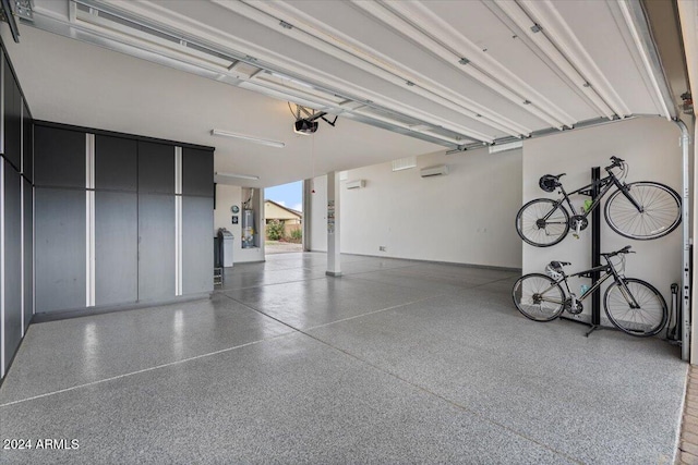 garage with a wall mounted AC and a garage door opener