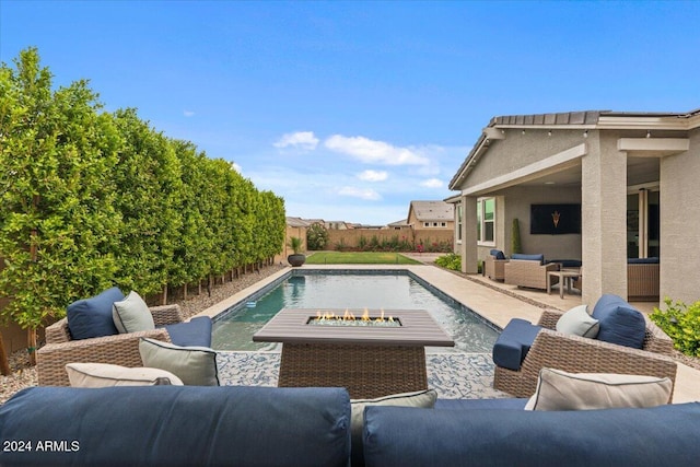 view of swimming pool with an outdoor living space with a fire pit and a patio