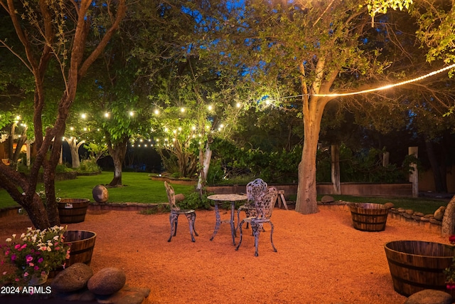 patio at twilight featuring a yard