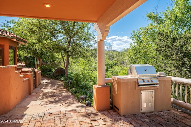 view of patio featuring area for grilling and a grill