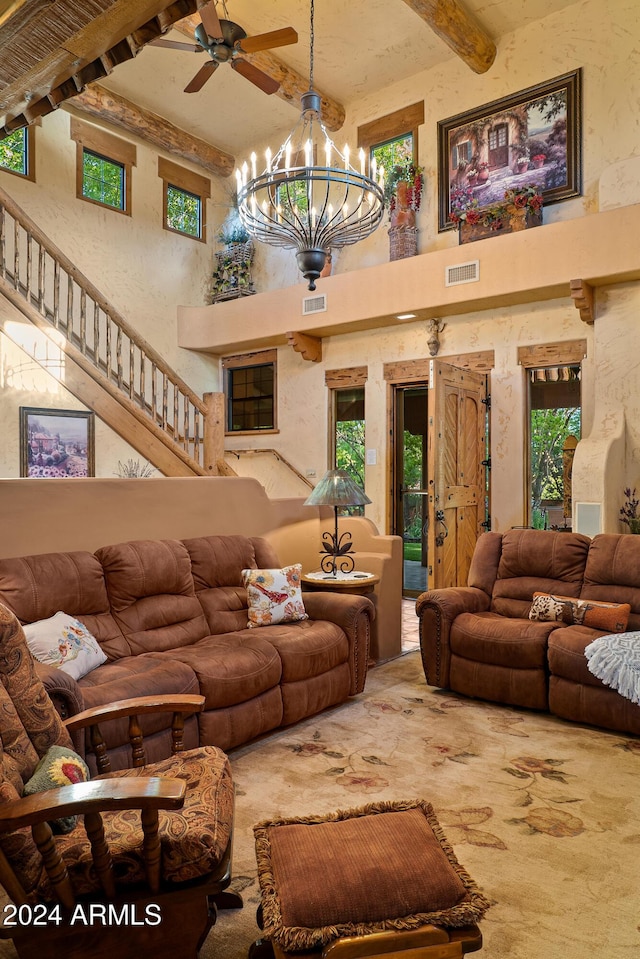 living room with a high ceiling, ceiling fan with notable chandelier, and beam ceiling