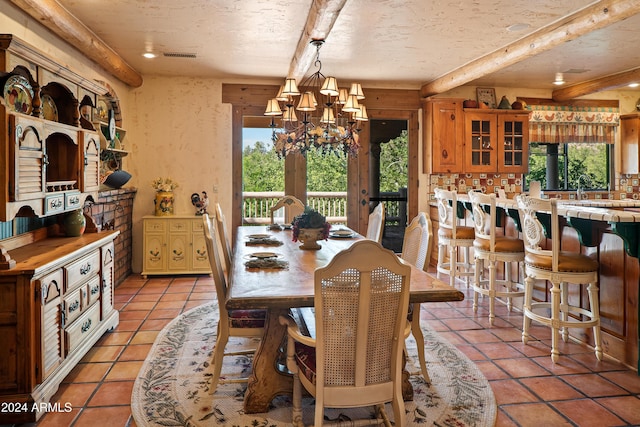 tiled dining space with plenty of natural light, a textured ceiling, and an inviting chandelier