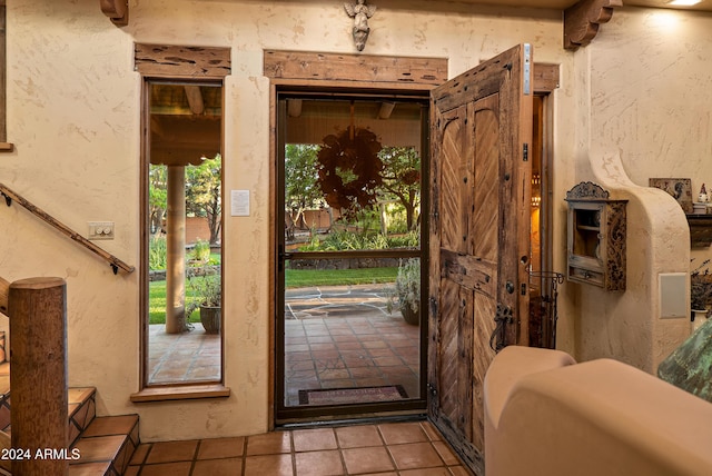 doorway to outside with light tile patterned floors