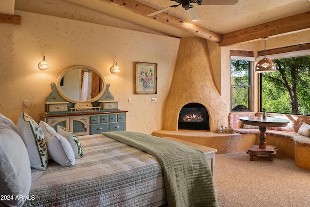 bedroom featuring beam ceiling, a fireplace, and carpet floors