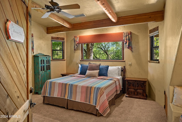 carpeted bedroom featuring beam ceiling, multiple windows, and ceiling fan