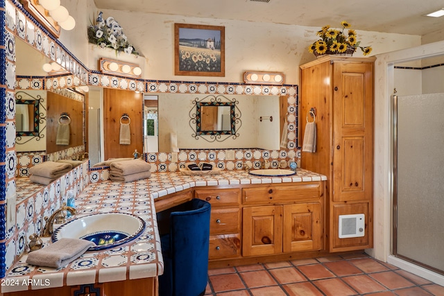 bathroom with tile patterned flooring, vanity, and walk in shower