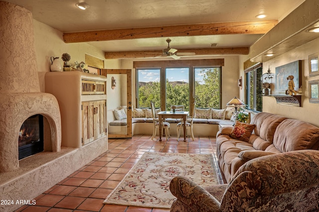 tiled living room with ceiling fan, beam ceiling, and a fireplace