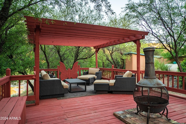 wooden deck featuring a pergola and an outdoor living space with a fire pit